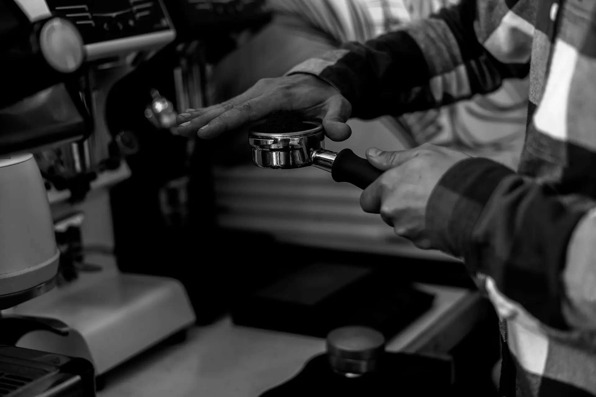 Barista verteilt Kaffeemehl in Siebträger Barista verteilt Kaffeemehl in Siebträger